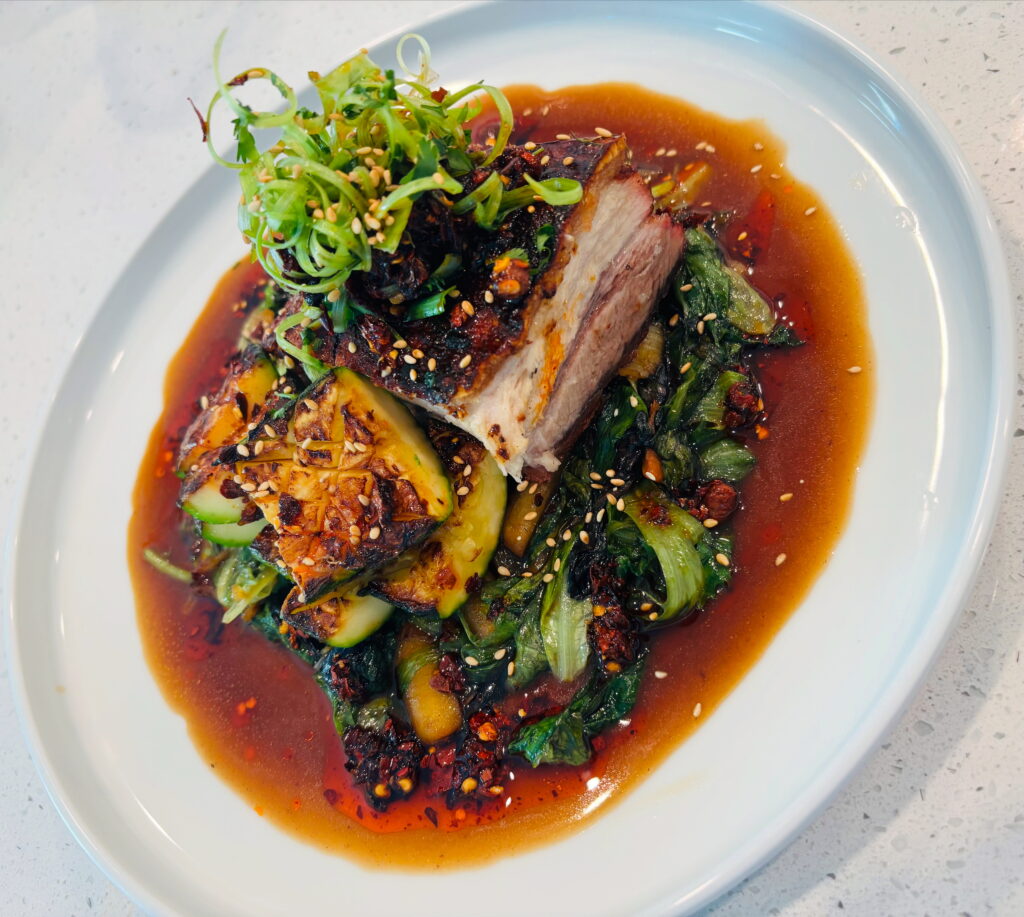 Braised crispy pork belly, charred zucchini, wilted spinach, soy jus